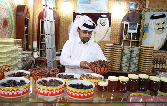 Um comerciante vende tâmaras e mel no comércio em Doha, a capital do Catar / Foto: AFP