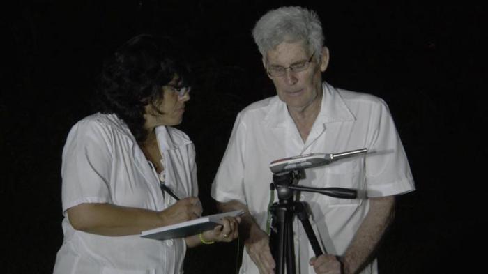 A doutora Yamile González Sánchez, chefa de departamento no Centro de Epidemiologia e Saúde Ambiental, e o doutor em Ciências Físicas, Carlos Barceló Pérez, realizam medições de ruído ambiente em horário noturno.